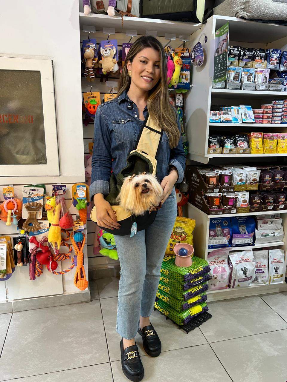 Camille, dona do Plaza Pet Laranjeiras, na loja com um cachorrinho na bolsa de transporte